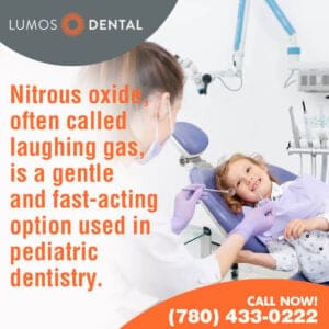 A dentist or dental professional, seen from behind, holds a dental mirror towards a smiling young child seated in a dental chair.