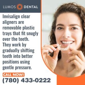 A smiling woman holds up a clear Invisalign aligner.