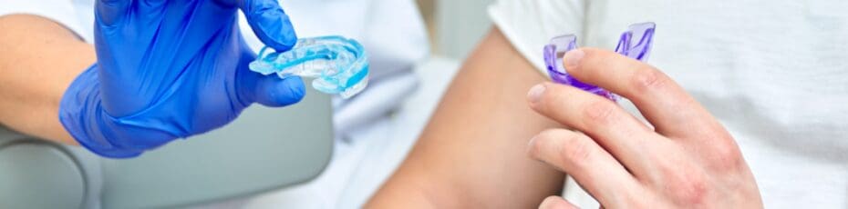 dentist doctor holds dental tray and shows the patient mouth guard