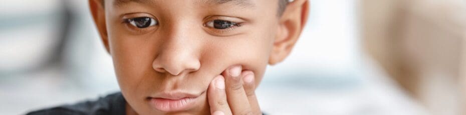Little boy suffering from a toothache at home